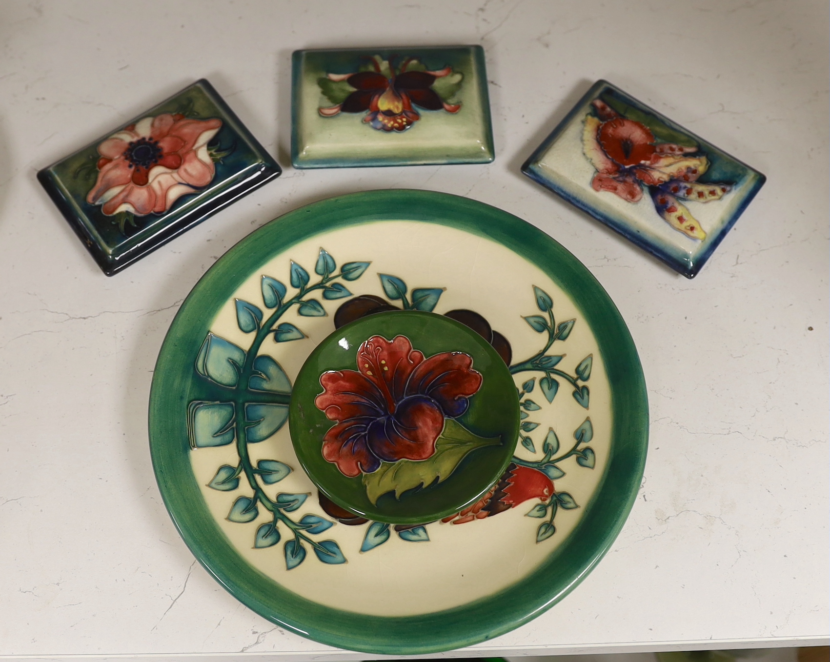 Three Moorcroft box lids, a pin dish and a larger dish (5)